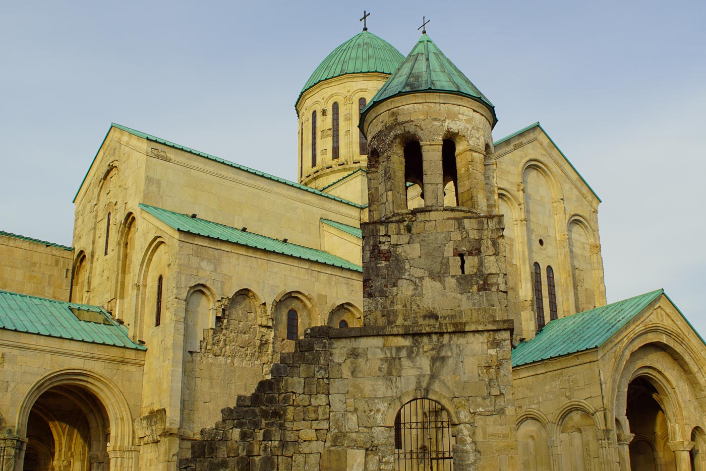 Zu sehen ist die Kathedrale von Kutaisi mit ihrem sandsteinfarbenem Gemäuer und Kupfer Grünen Dächern.