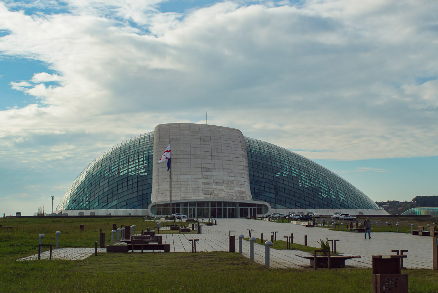 Zu sehen ist das futuristische Parlamentsgebäude in tiblissi es hat die Form eines halben Ei´s was auf der Seite liegt und von einem Betonstreifen umfasst wird. ansonsten ist es verglast und im Inneren erkennt man die einzelnen Gebäude.
